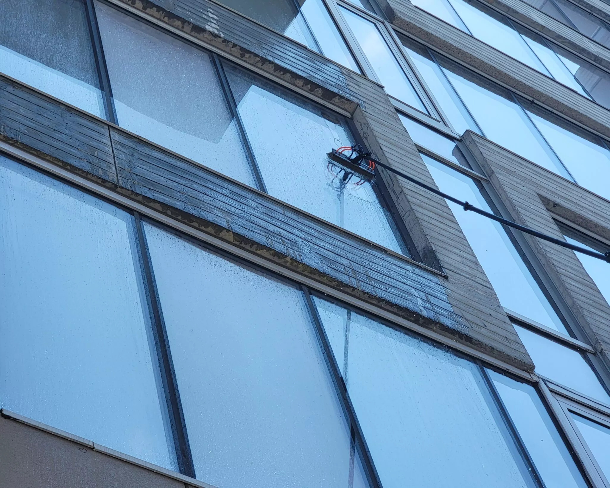 Two side-by-side pictures of a window, one dirty and the other spotless after cleaning.
